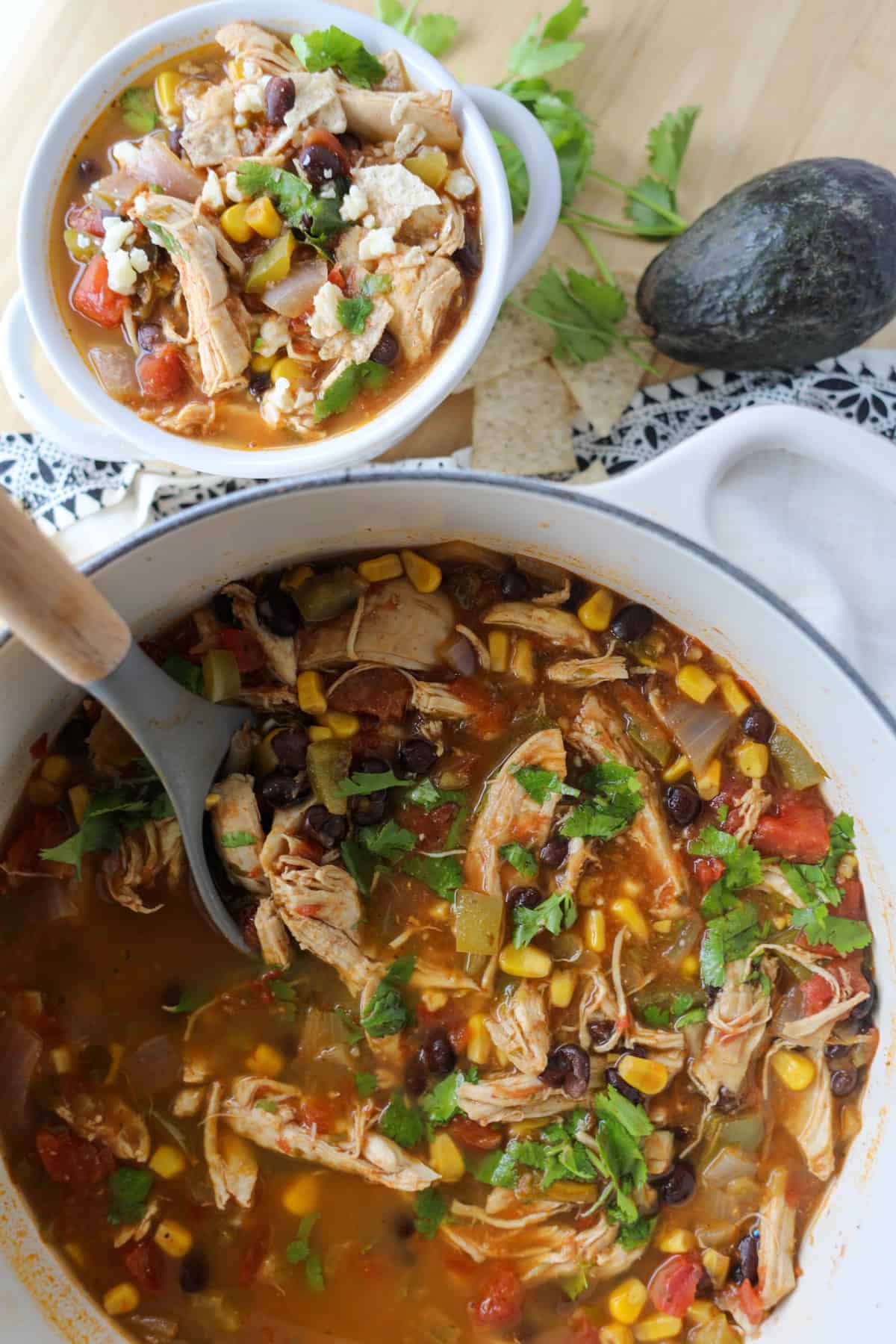 chicken taco soup on the stovetop in a stock pot with a ladle in the pot