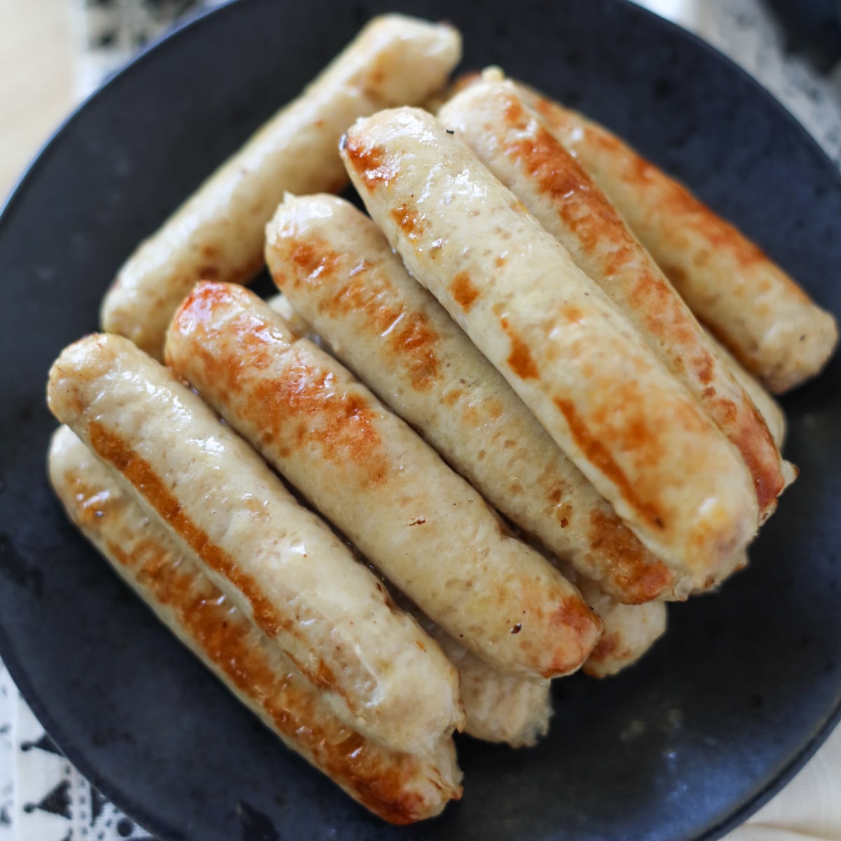 cooked chicken breakfast sausage stacked on a black plate