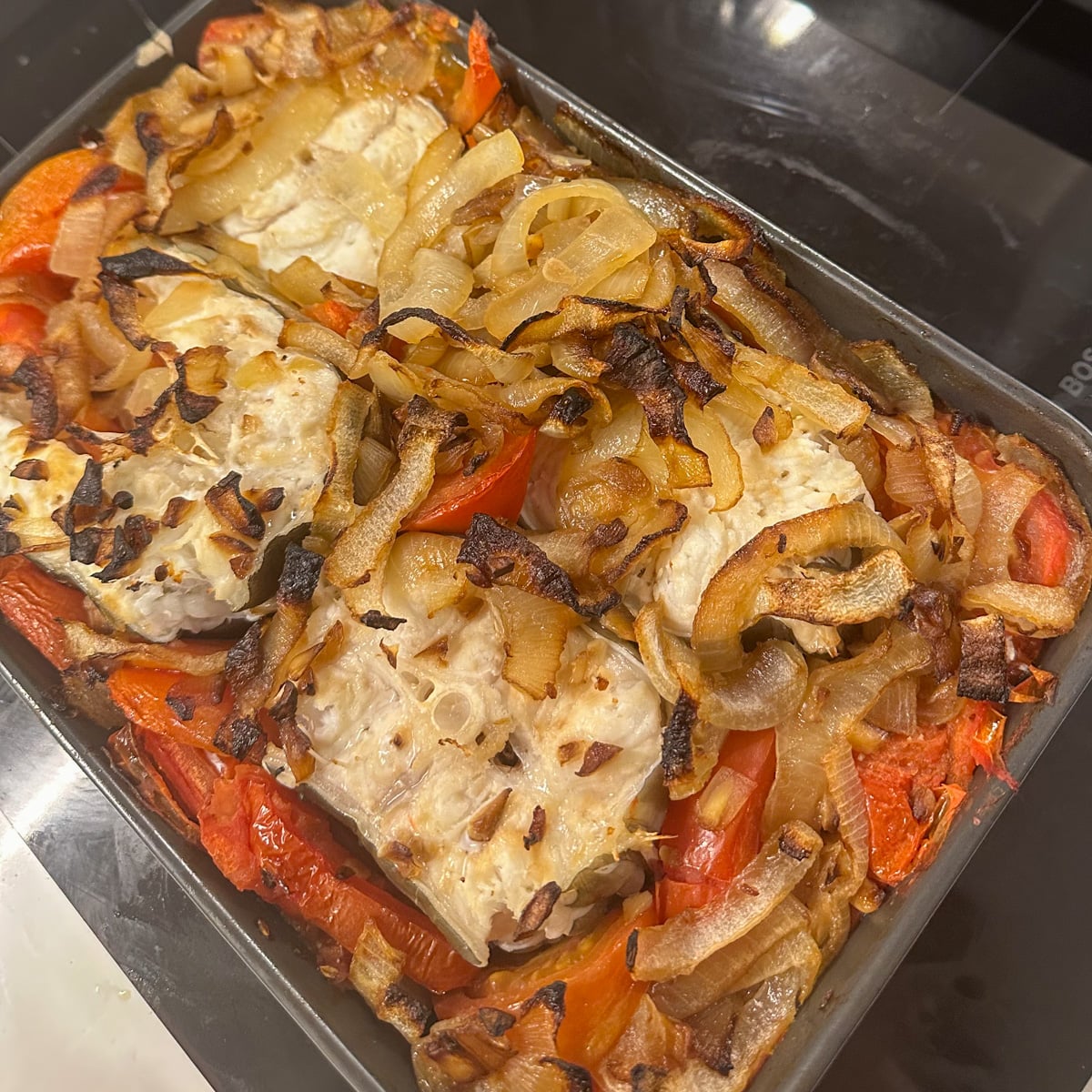 freshly baked eel in a pan with vegetables
