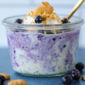berry cheesecake overnight oats with frozen blueberries mixed in