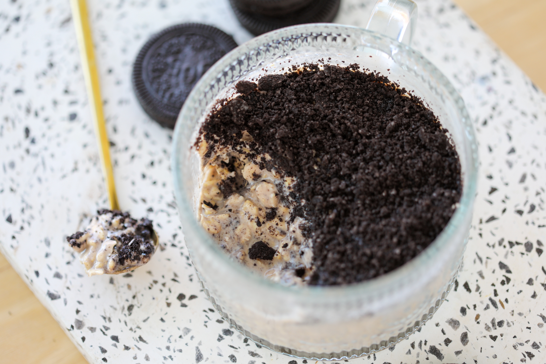 cookies and cream protein overnight oats at a side angle with a spoonful on the side