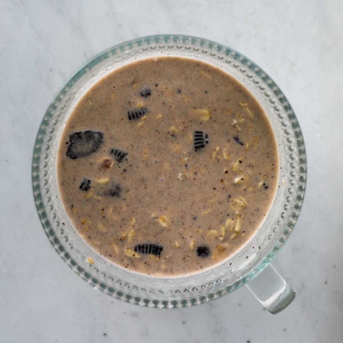 spooning the cookies and cream protein oats into the bowl