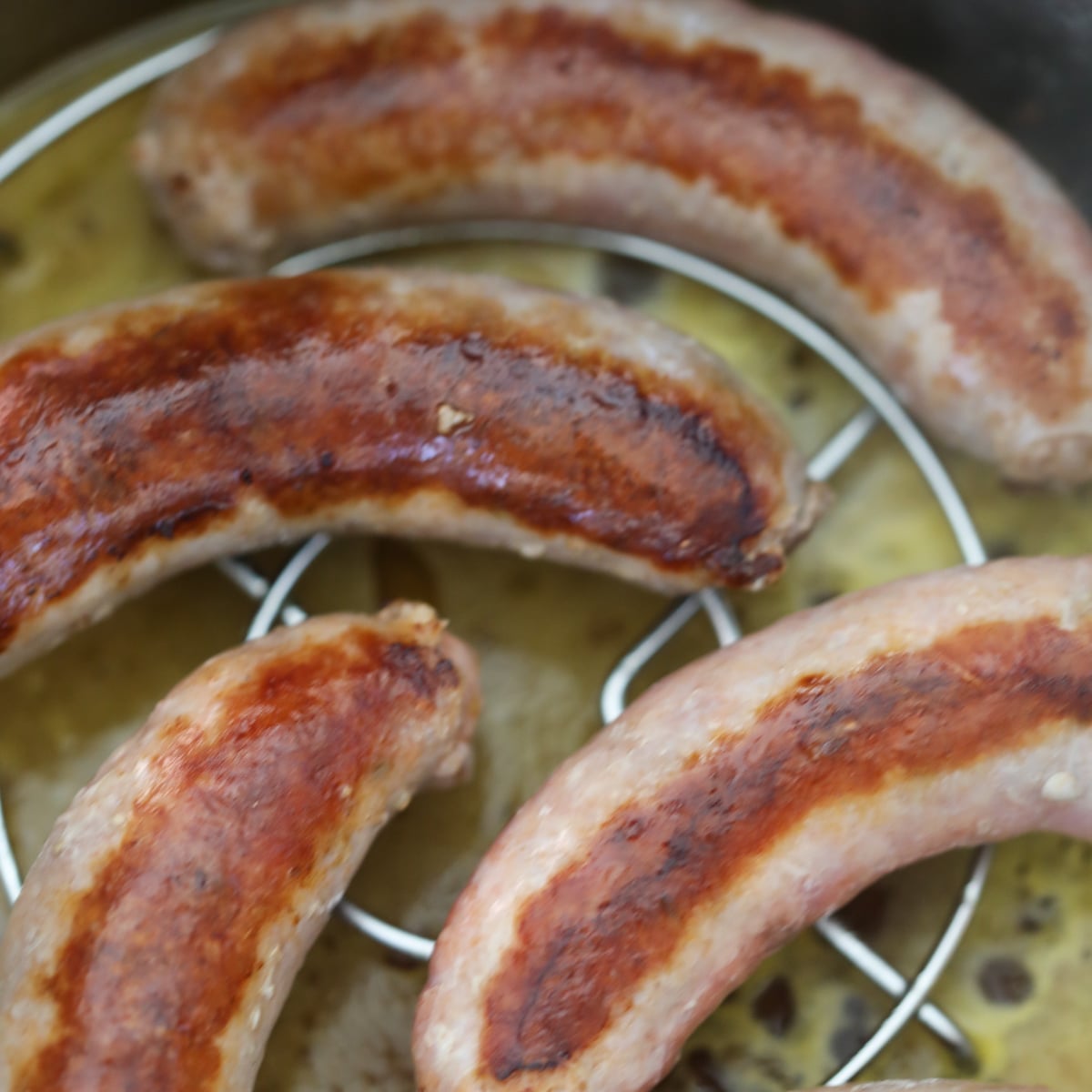 setting the italian sausages on a rack before cooking them in the pressure cooker