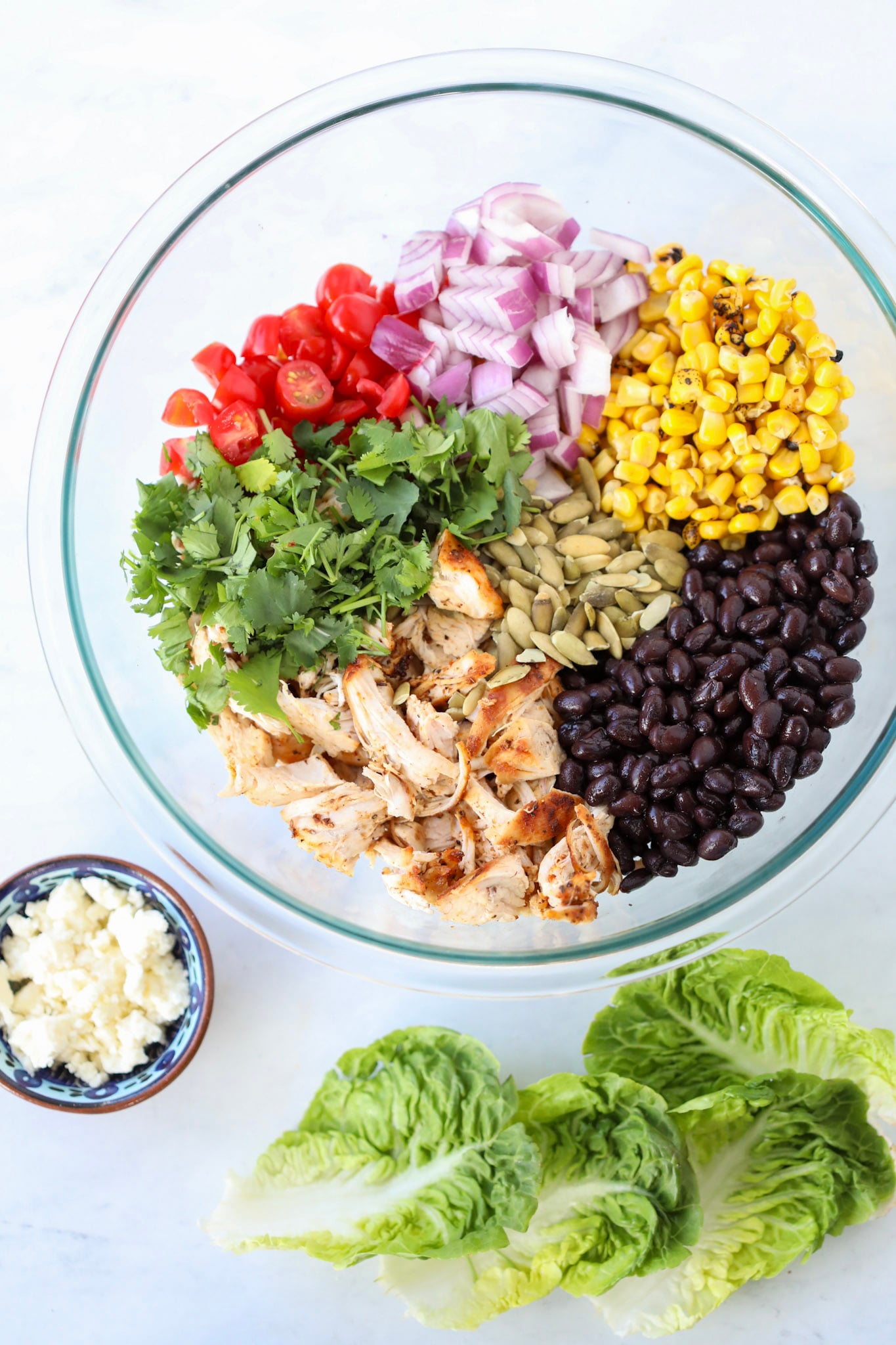 southwestern chicken salad in a clear bowl before adding to lettuce wraps with cotija cheese