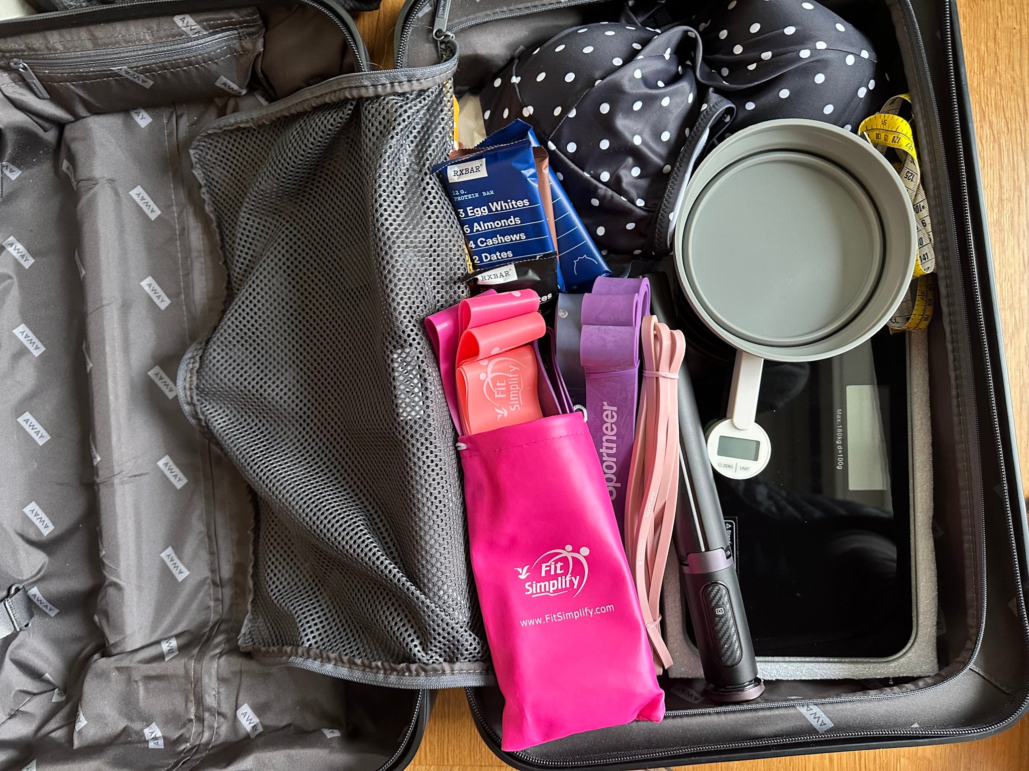 suitcase with exercise bands and high prteoin snacks for travel