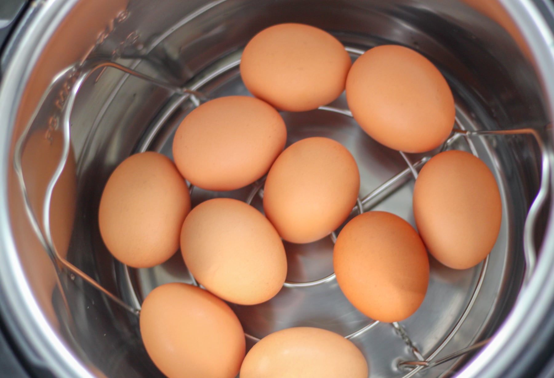 adding the large eggs to the pressure cooker rack