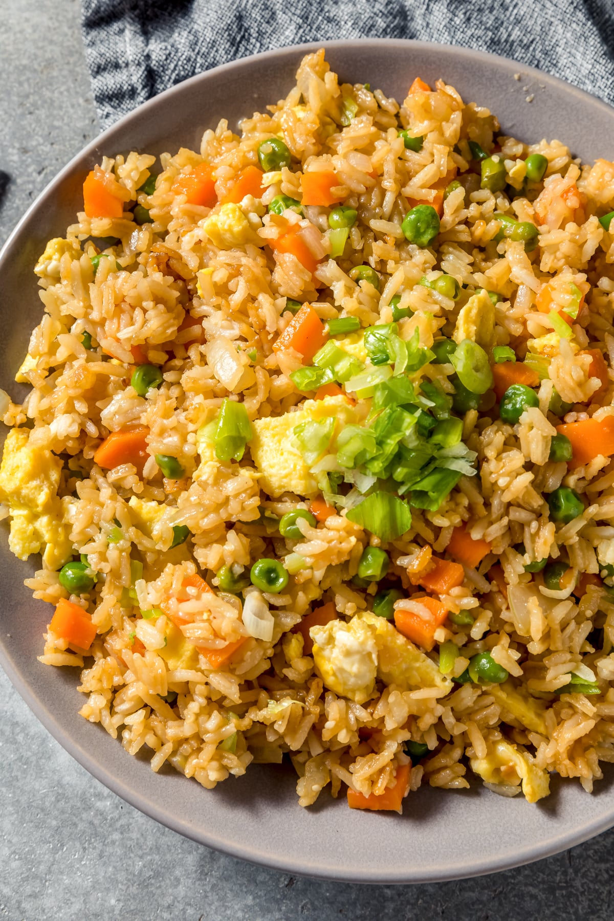 blackstone chicken fried rice with frozen vegetables  in a gray serving dish after cooking on a flat top griddle