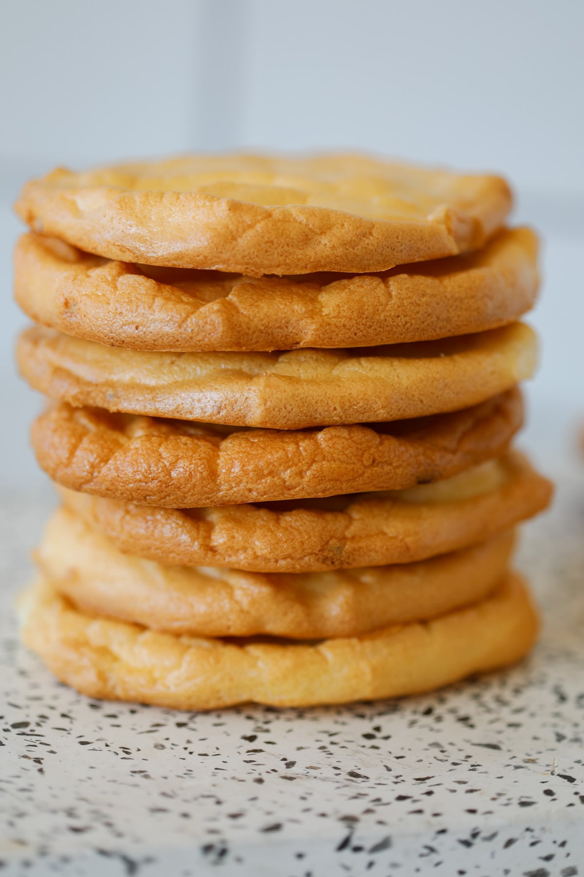 fluffy cottage cheese cloud bread stacked up on a white cutting board