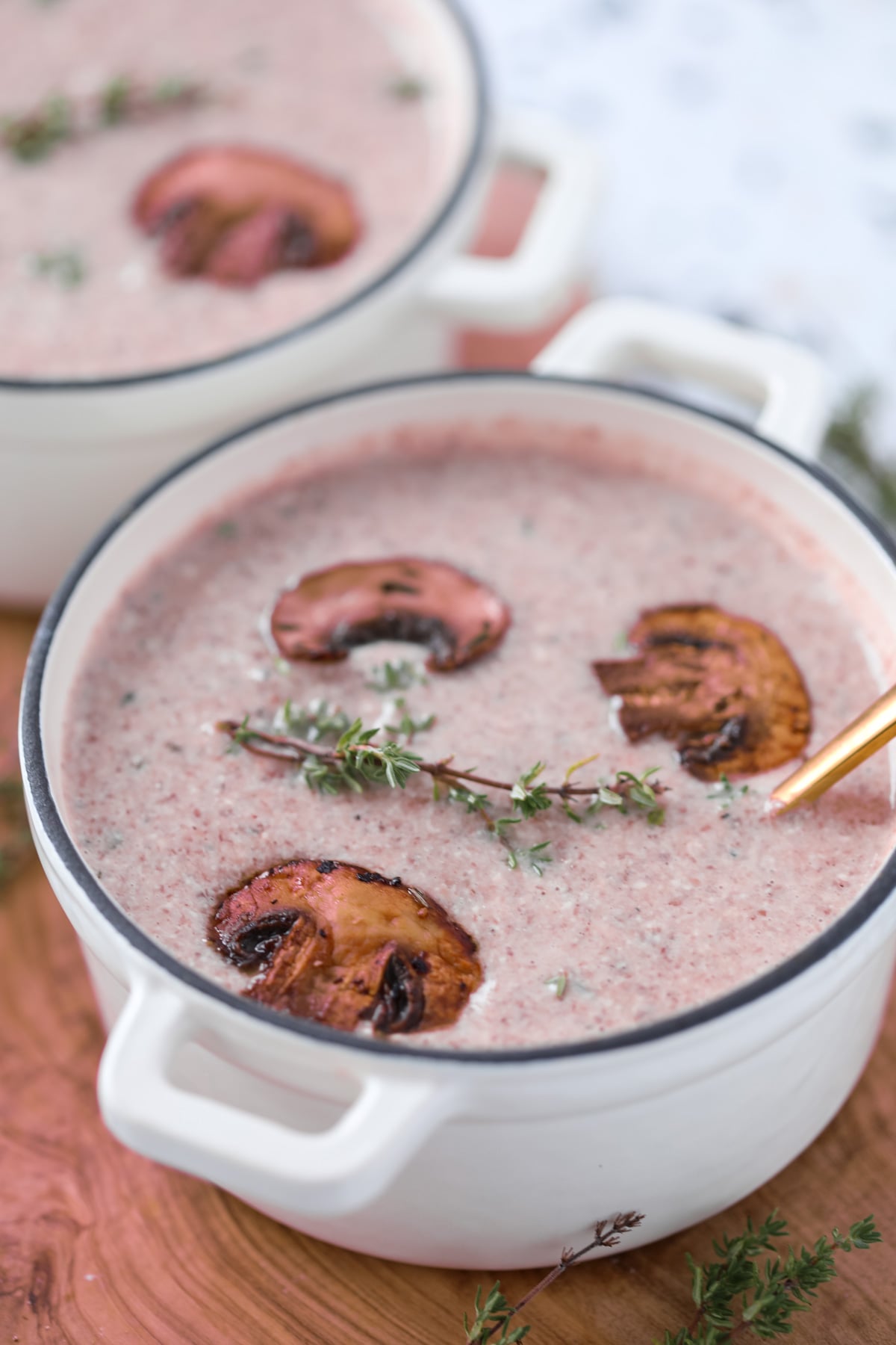 creamy mushroom soup with cottage cheese and bone broth in a soup bowl topped with fresh mushrooms and thyme