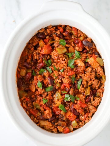 healthy slow cooker turkey chili in a white crock pot