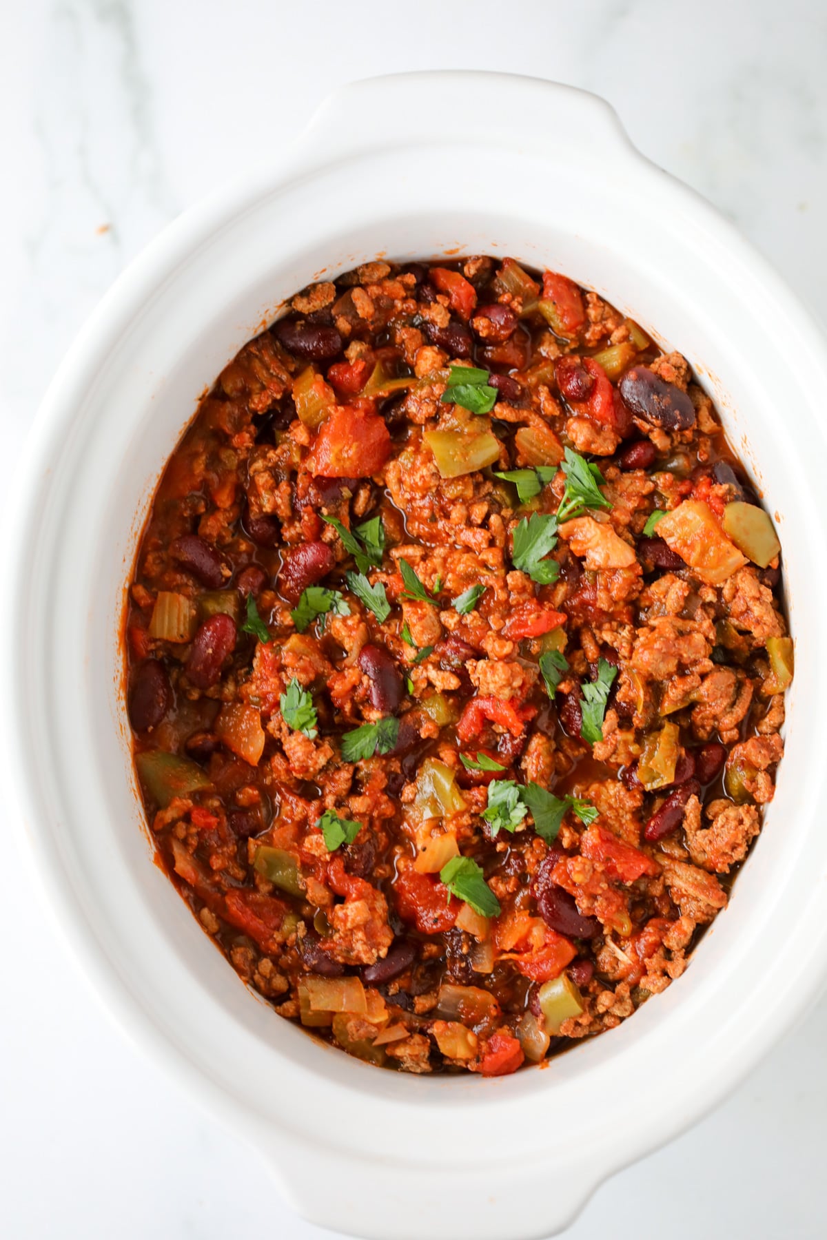 healthy slow cooker turkey chili in a white crock pot